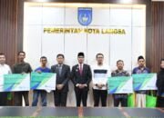 PJ.walikota langsa menyerahkan secara simbolis kartu BPJS bagi pekerja rentan